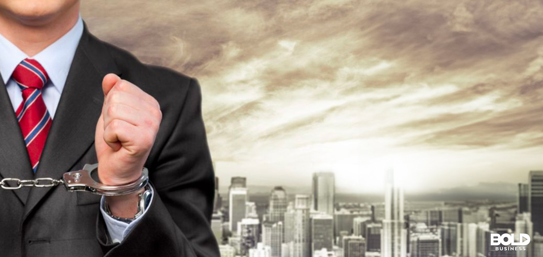 a photo of a businessman in handcuffs with a background of a city under dark clouds, thus depicting a crisis of overcriminalization