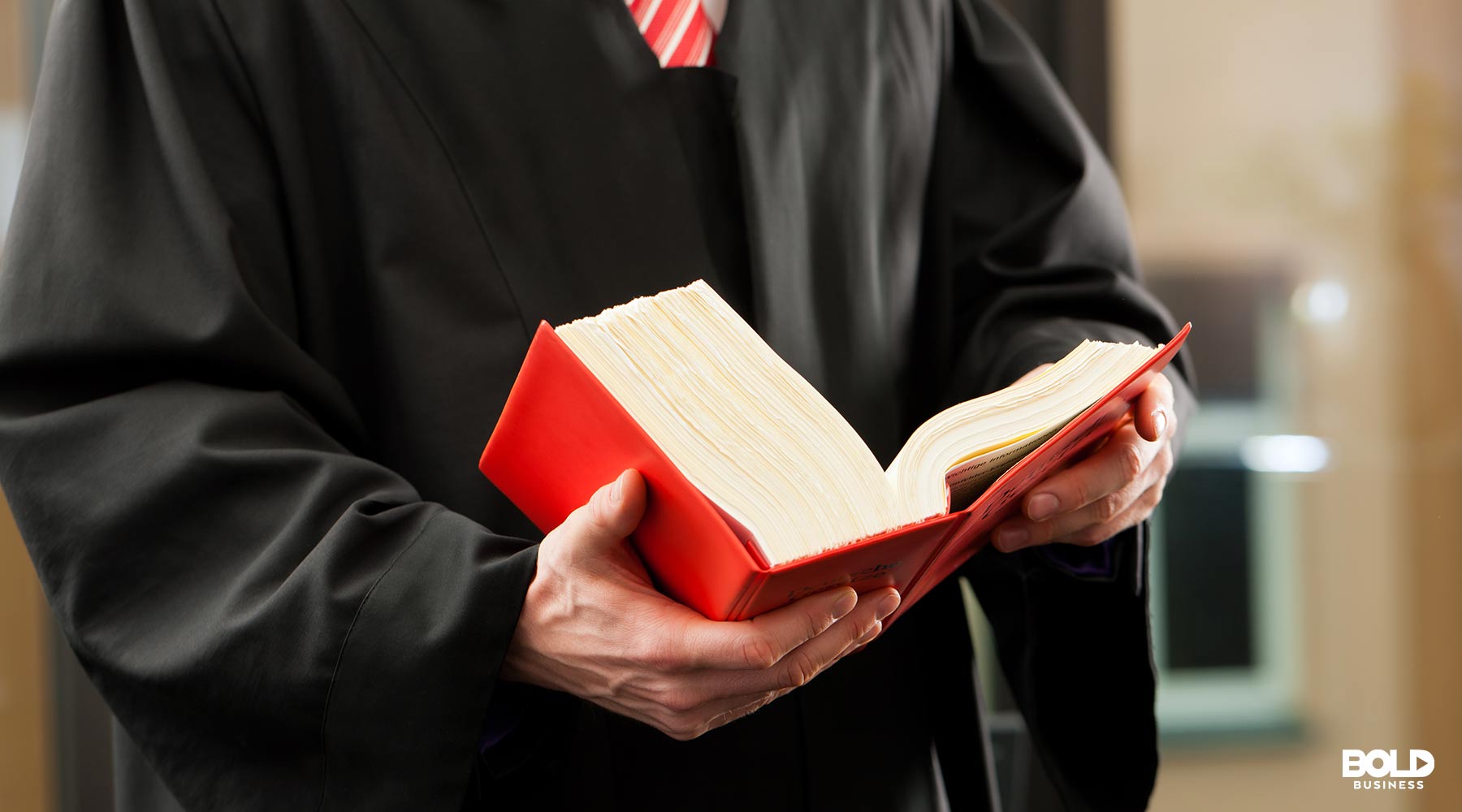 a photo of a lawyer holding a book on self-driving car technology amid the war between Google and Waymo