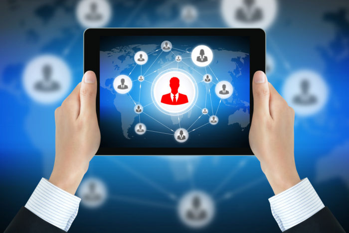 a photo of a man's hands holding a tablet that has its screen opened on an image that is related to Digital Transformation