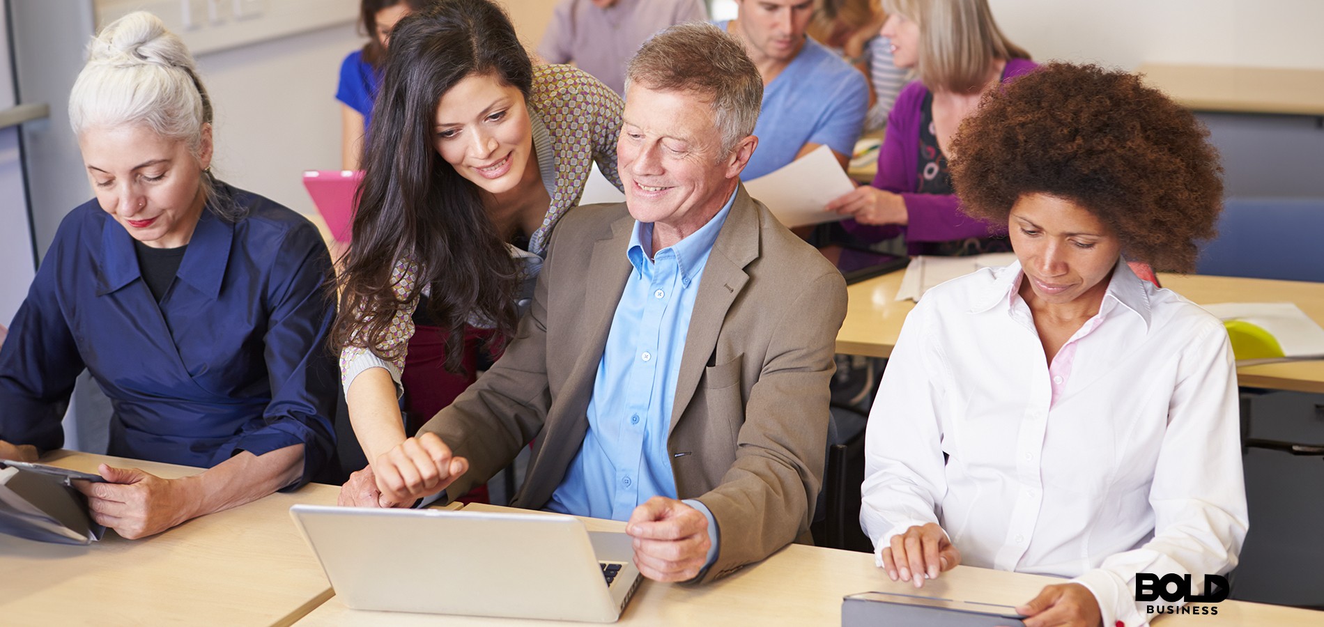 group of adults working together on digital topics in a classroom to overcome the causes of digital divide