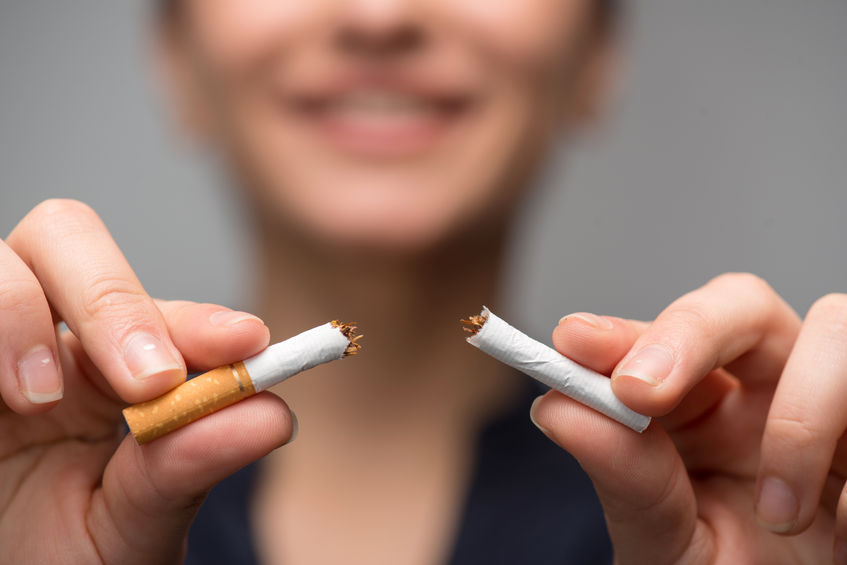 a photo of a woman breaking a cigarette in two because of the bold impact of the SmartQuit app