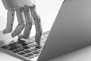 AI robot hand typing on laptop keyboard image