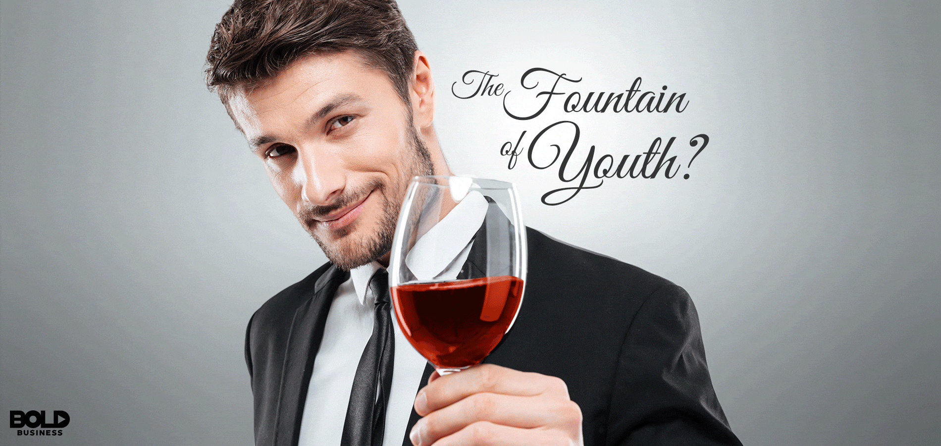 new study on alcohol and longevity: a man holding a glass of wine