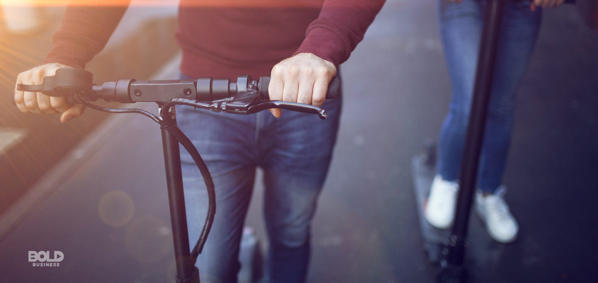 a photo of two people riding e-scooters on a sidewalk even amid rising concerns about scooter safety