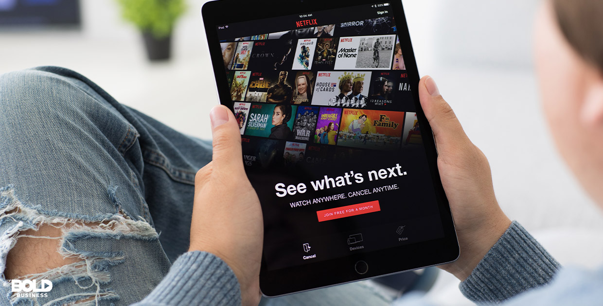a photo of a girl holding an iPad with its screen open on the Netflix menu of movies with the words " See what's next." written on it; the IPad is the focus of the photo, thus depicting the reality of Netflix innovation