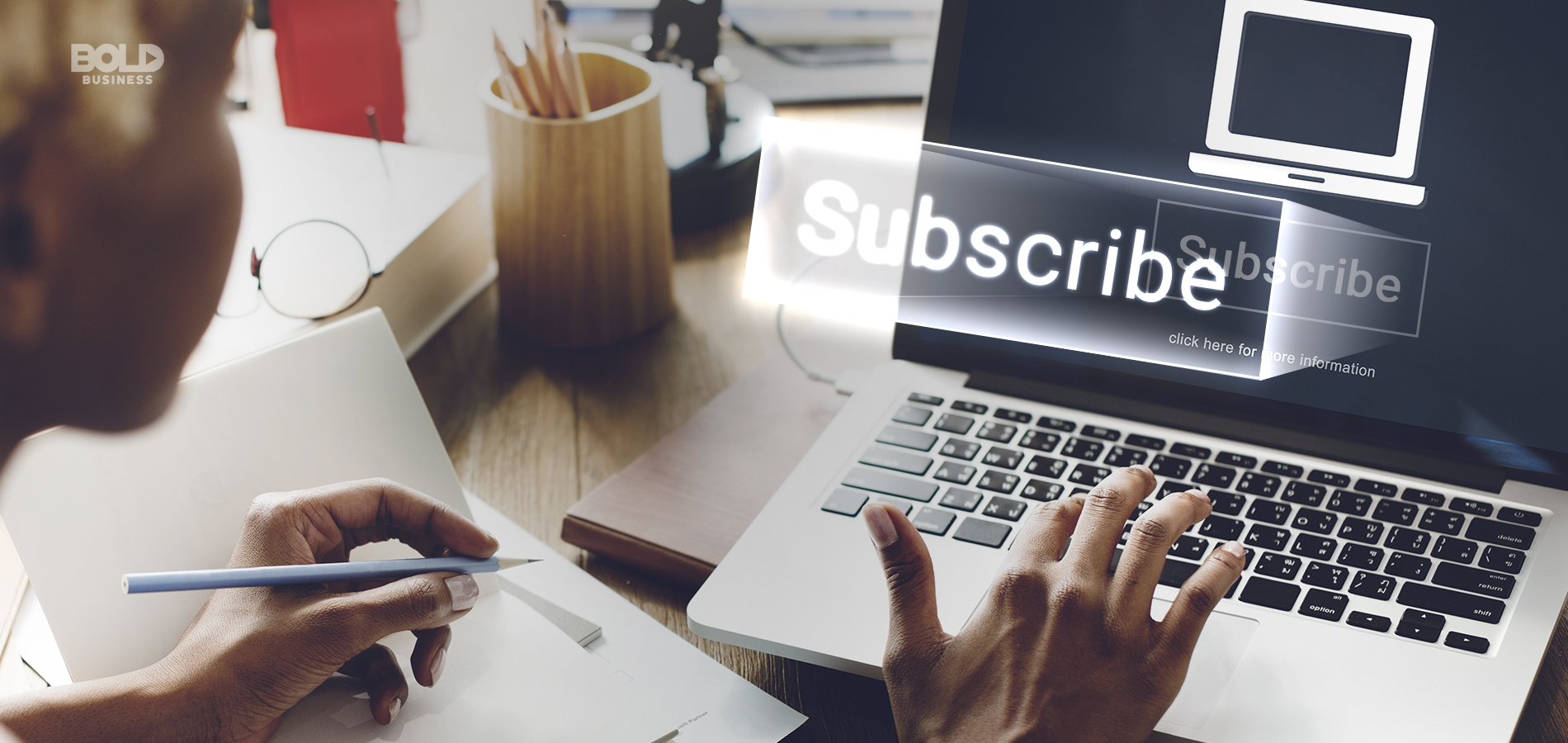 a photo of a woman working on her laptop with the word "SUBSCRIBE" emerging from the screen amid the rising subscription economy