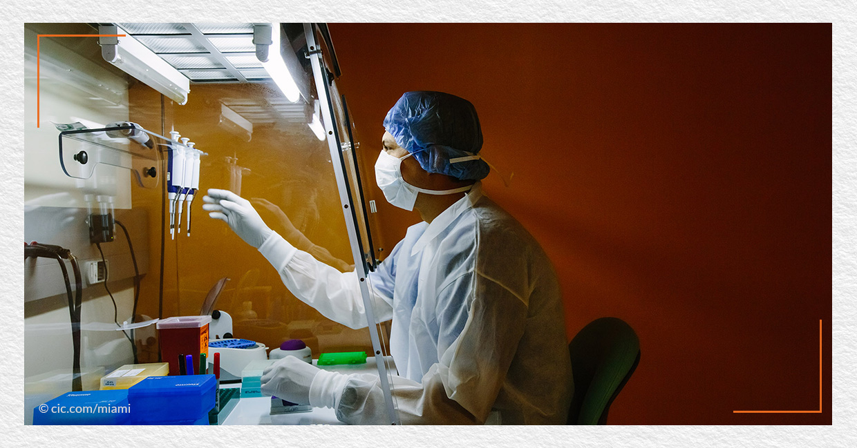 a photo of a scientist in a lab coat conducting an experiment in one of the laboratories at Cambridge Innovation Center Miami (CIC Miami), which is led by Natalia Martinez-Kalinina