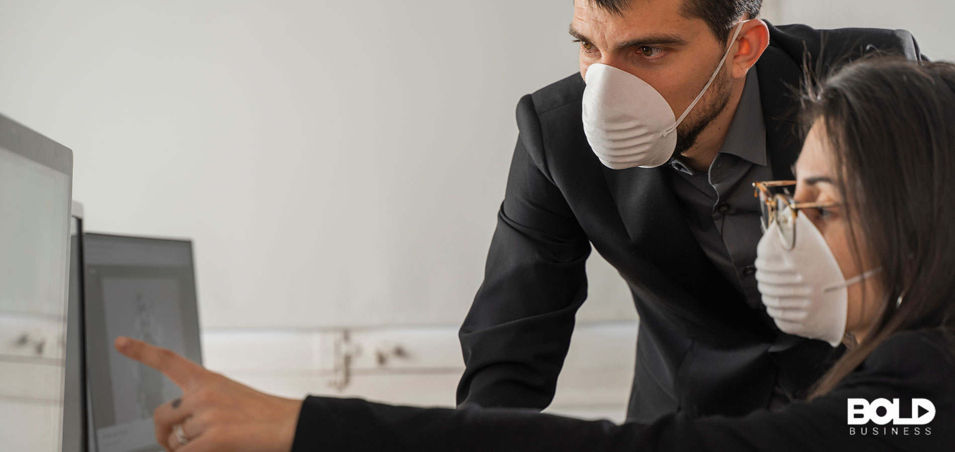 A supervisor and worker in face masks