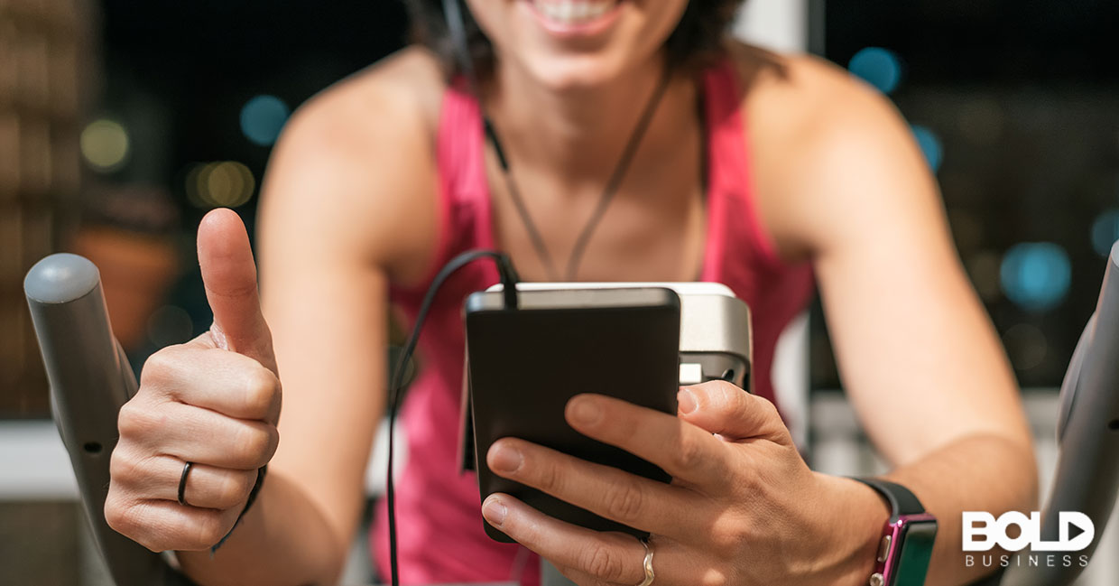 Someone riding an exercise bike and using an app