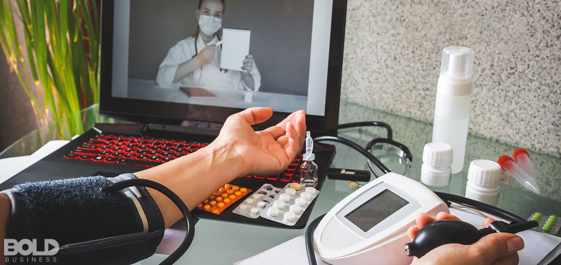A patient taking their blood pressure while a doctor watches on screen