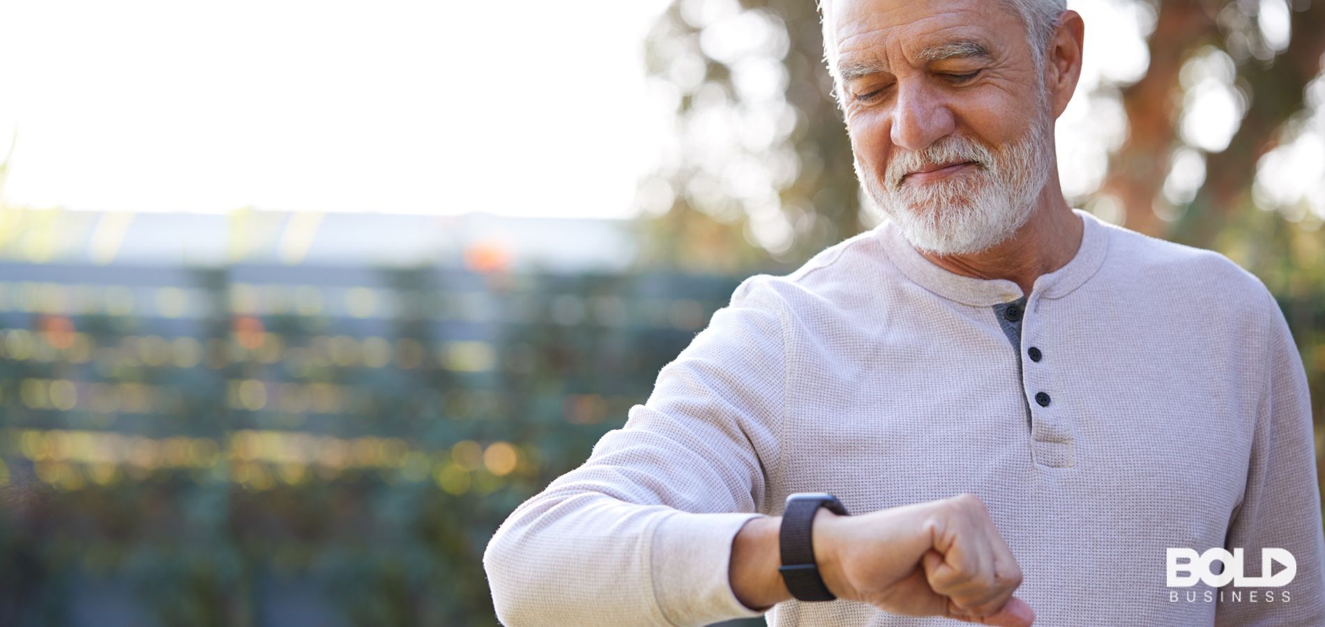 An older dude checking his wearable health monitor