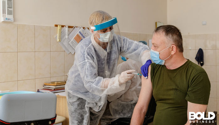 A medical professional giving a soldier a shot