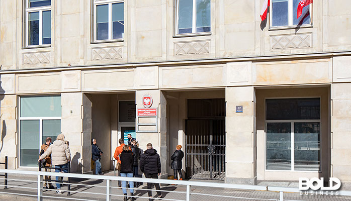 A bunch of people chilling outside of an embassy