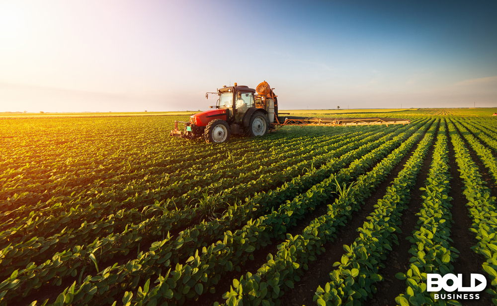 Tractor spraying pesticides on soybean field with sprayer at spring