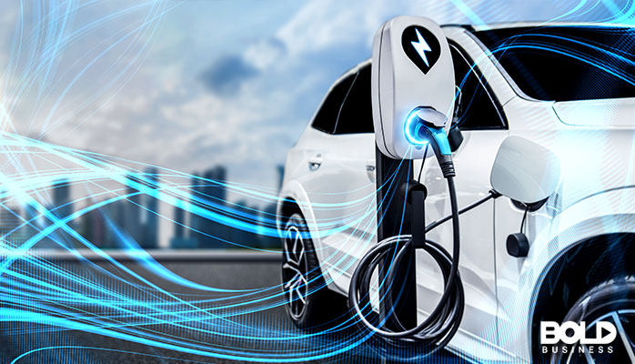 An electric car being charged by something blue
