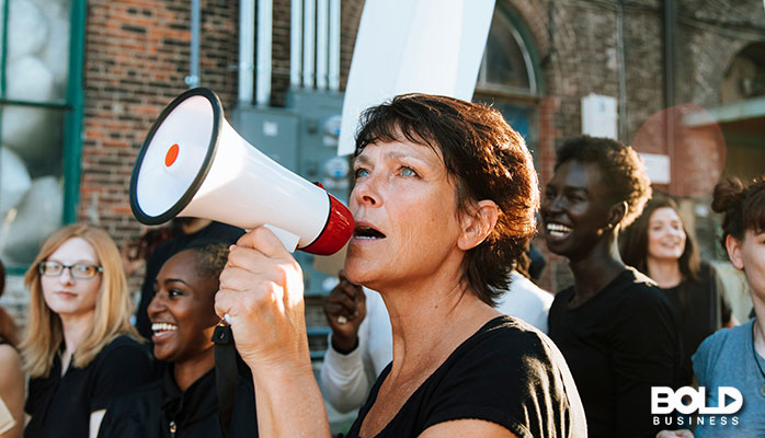 A woman using a bullhorn to criticize government