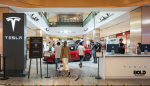 people in a mall showing EV sales are slowing