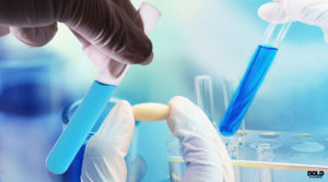 someone holding a pill and a test tube