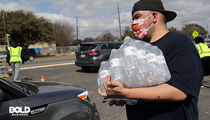 a dude carrying a case of water
