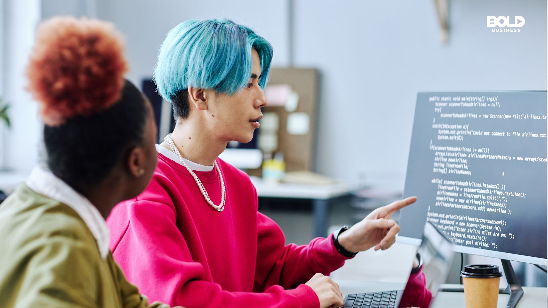 Two Gen Z professionals collaborating on coding at a computer workstation, with a focus on teamwork and technological expertise in the workplace.