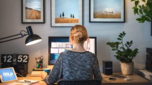 Gen Z professional working from a home office, featuring a dual-monitor setup, personalized decor, and modern technology, reflecting the hybrid work culture.